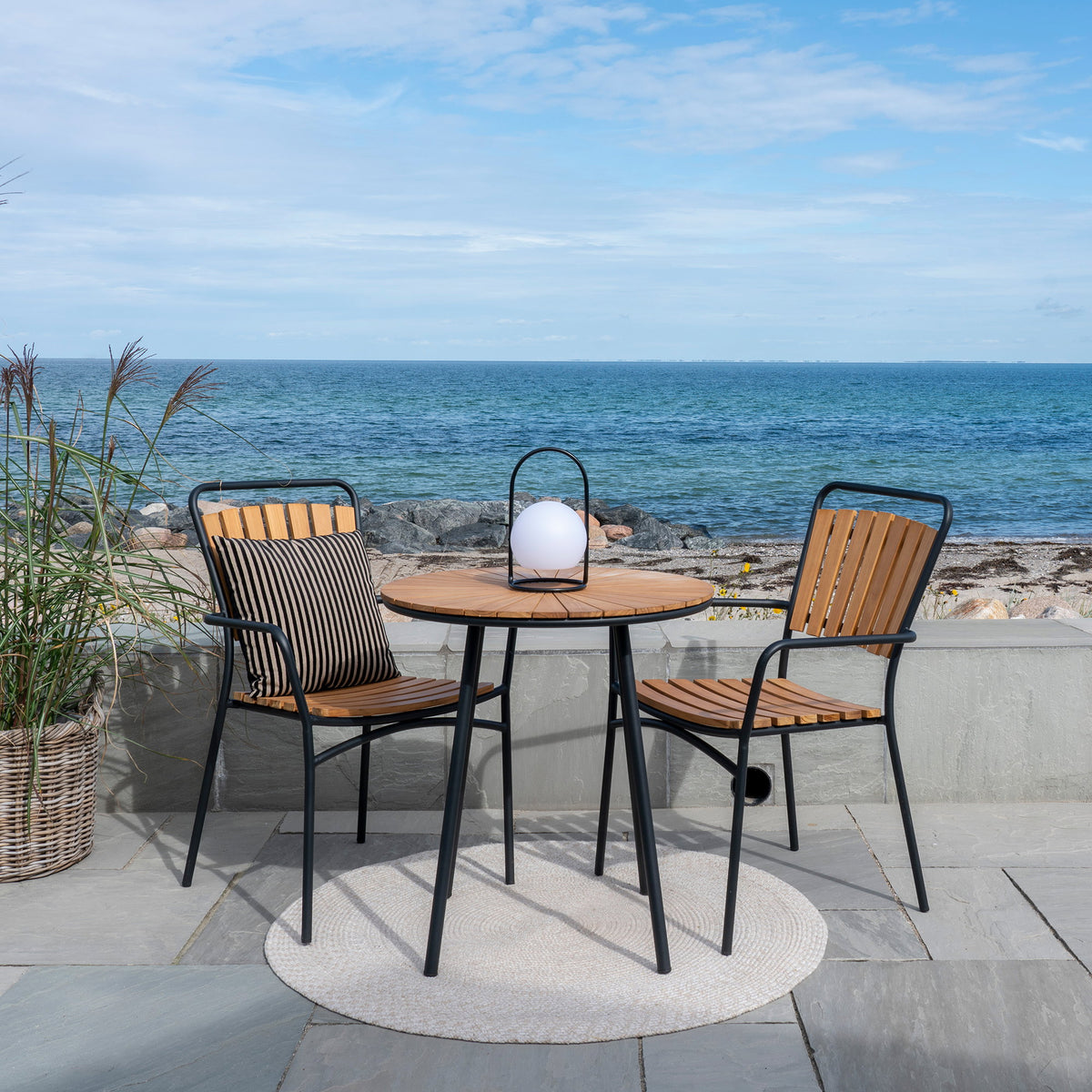 Table bistrot CLEVELAND en teck naturel et métal noir – vue d’ambiance